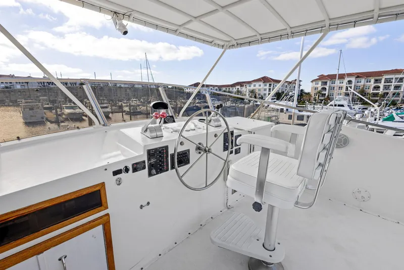 Slide: The Image of Helm of 1987 Hatteras 68 Cockpit Motor Yacht with marina view. - 13