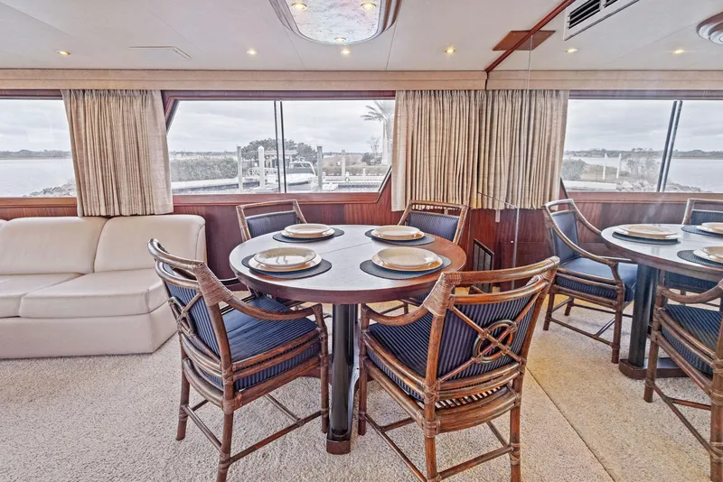 Slide: The Image of Luxurious dining area in 1987 Hatteras 68 Cockpit Motor Yacht with elegant seating and scenic views. - 18