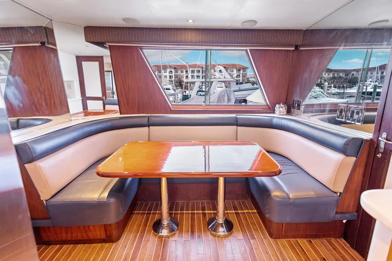 Slide: The Image of Luxurious dining area in 1987 Hatteras 68 Cockpit Motor Yacht with marina view. - 20