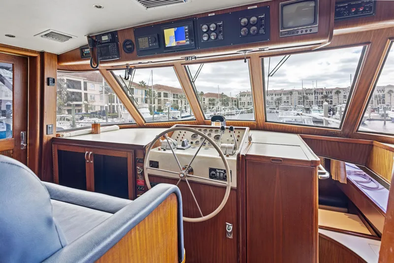 Slide: The Image of Interior helm of 1987 Hatteras 68 Cockpit Motor Yacht with wooden finish and navigation controls. - 21