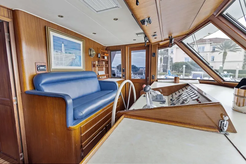 Slide: The Image of Interior of 1987 Hatteras 68 Cockpit Motor Yacht with blue seating and wooden helm. - 22
