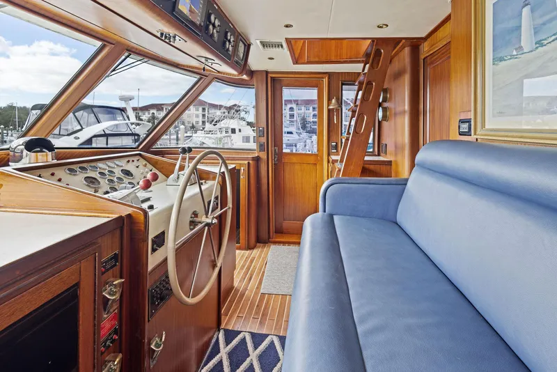 Slide: The Image of Interior of 1987 Hatteras 68 Cockpit Motor Yacht with helm and blue seating. - 23