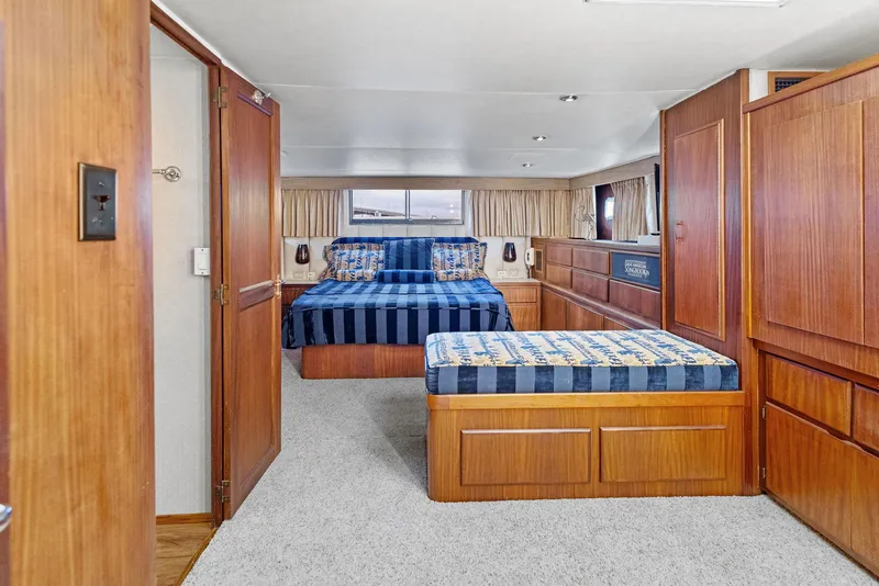 Slide: The Image of Interior of 1987 Hatteras 68 Cockpit Motor Yacht with twin beds and wood paneling. - 24