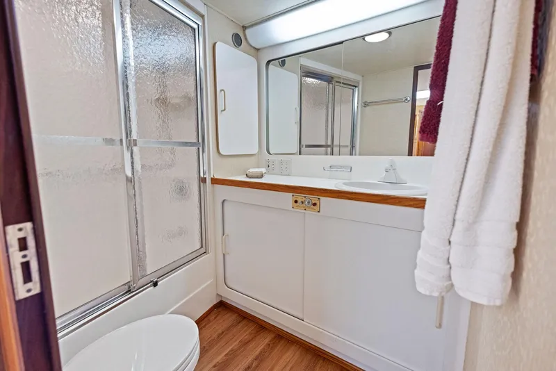 Slide: The Image of Bathroom of 1987 Hatteras 68 Cockpit Motor Yacht with shower, vanity, and wood flooring. - 27