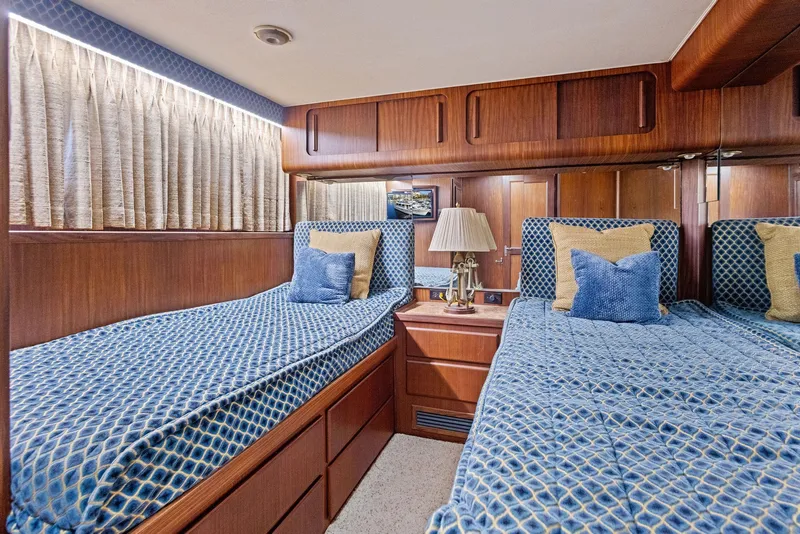 Slide: The Image of Interior of 1987 Hatteras 68 Cockpit Motor Yacht with twin beds and wooden paneling. - 29