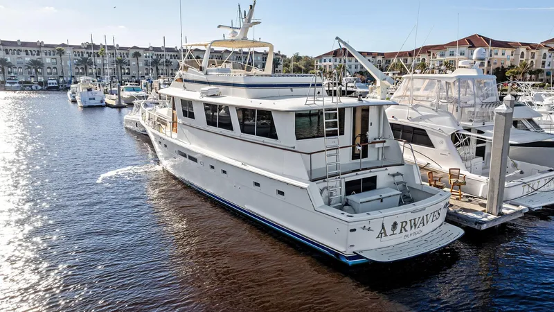 Slide: The Image of 1987 Hatteras 68 Cockpit Motor Yacht docked in marina, surrounded by other boats. - 3