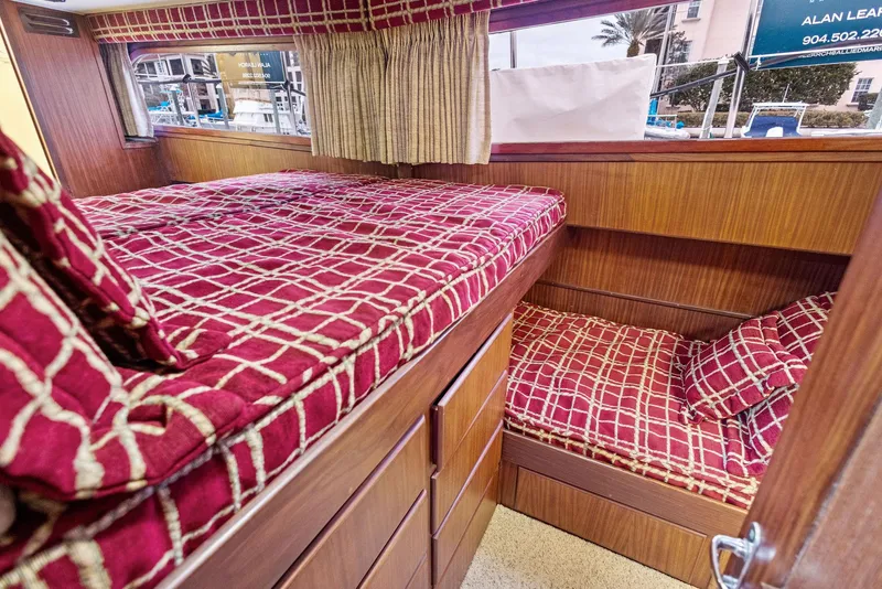 Slide: The Image of Cozy cabin interior of 1987 Hatteras 68 Cockpit Motor Yacht with red patterned bedding. - 31