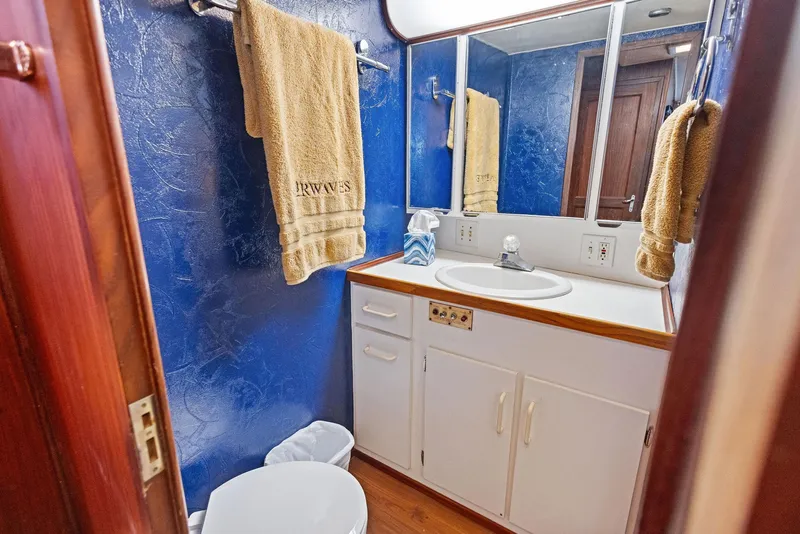 Slide: The Image of Luxurious bathroom in 1987 Hatteras 68 Cockpit Motor Yacht with blue walls and white fixtures. - 32