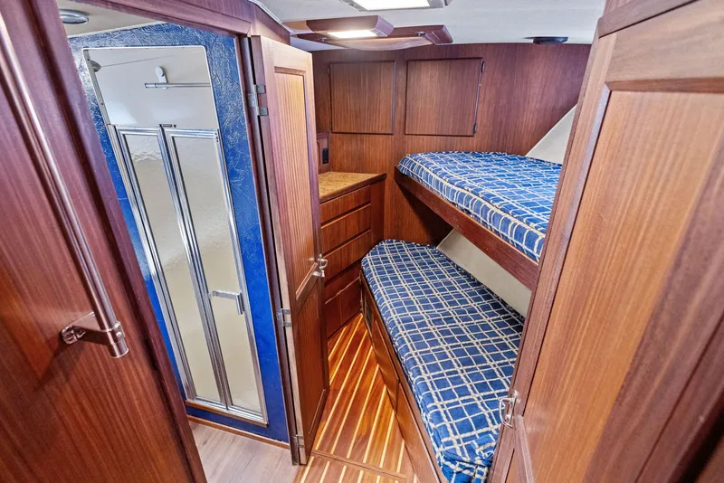 Slide: The Image of Interior of 1987 Hatteras 68 Cockpit Motor Yacht with bunk beds and wooden cabinetry. - 33