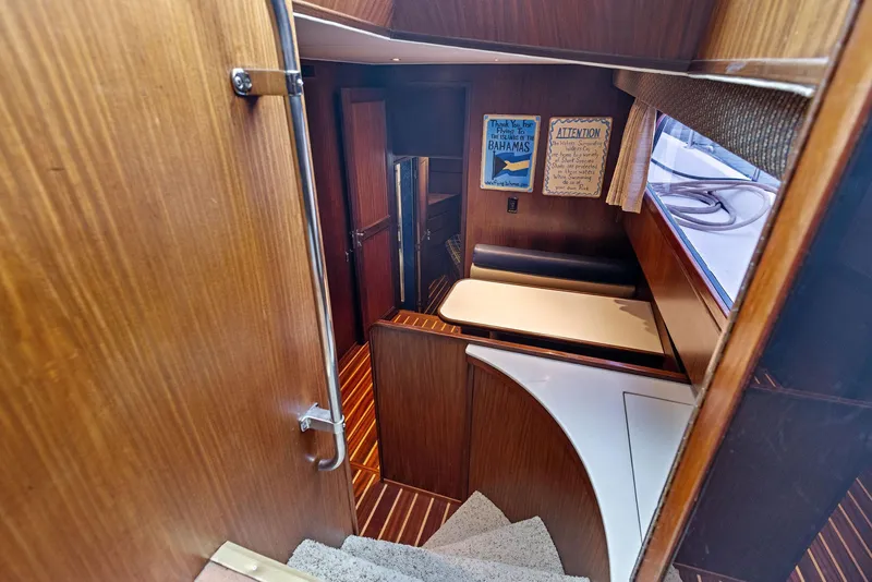 Slide: The Image of Interior of 1987 Hatteras 68 Cockpit Motor Yacht with wood paneling and cozy seating area. - 35