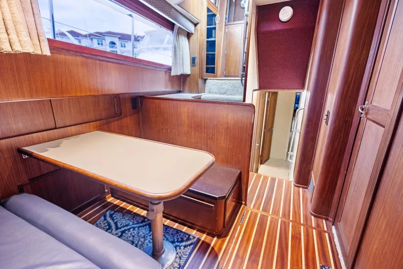 Slide: The Image of Interior of 1987 Hatteras 68 Cockpit Motor Yacht with wood paneling and dining area. - 36