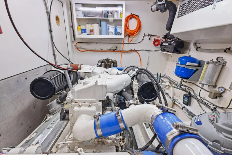 Slide: The Image of Engine room of 1987 Hatteras 68 Cockpit Motor Yacht, showcasing mechanical components and storage. - 41
