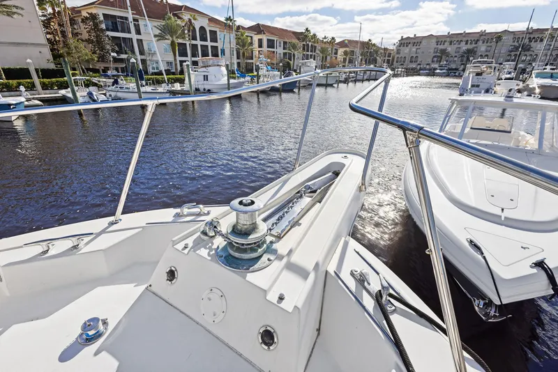 Slide: The Image of 1987 Hatteras 68 Cockpit Motor Yacht docked in a marina, surrounded by water and boats. - 6