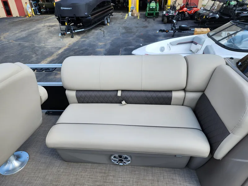 Slide: The Image of 2023 Sun Tracker SF24 boat interior with beige seating and speaker. - 13