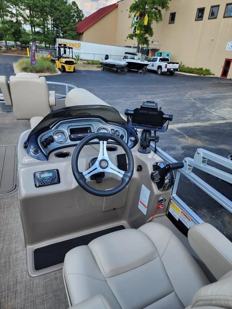 Slide: The Image of 2023 Sun Tracker SF24 boat dashboard with steering wheel and controls. - 5