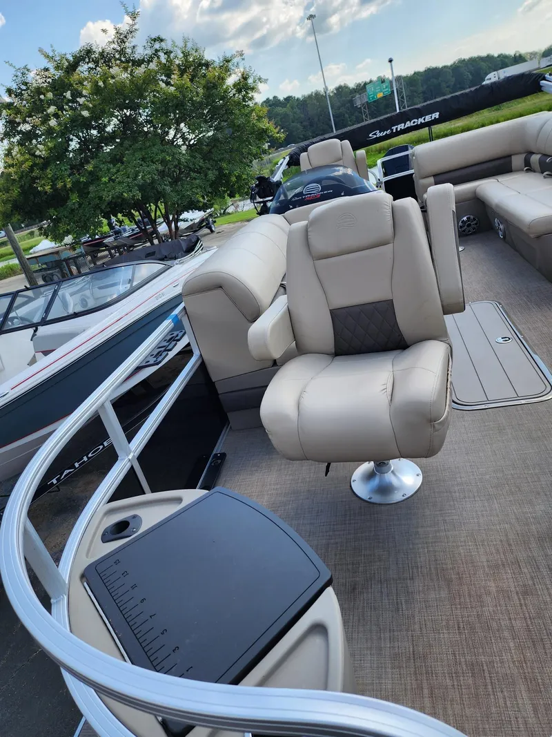 Slide: The Image of 2023 Sun Tracker SF24 pontoon boat with beige seating and spacious deck. - 6