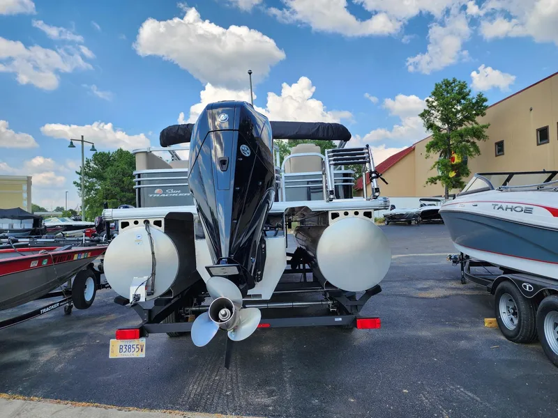 Slide: The Image of 2023 Sun Tracker SF24 pontoon boat with outboard motor in a parking lot. - 7