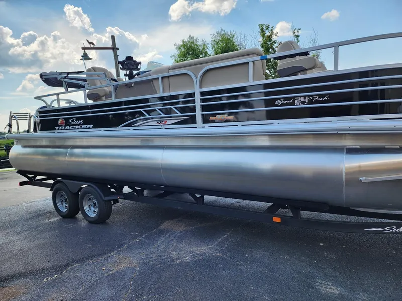 Slide: The Image of 2023 Sun Tracker SF24 pontoon boat on a trailer under a blue sky. - 8