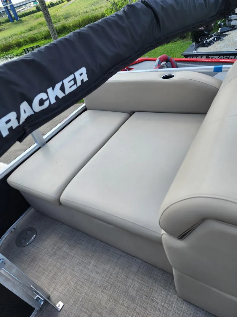 Slide: The Image of 2023 Sun Tracker SF24 boat with beige seating and protective cover. - 9