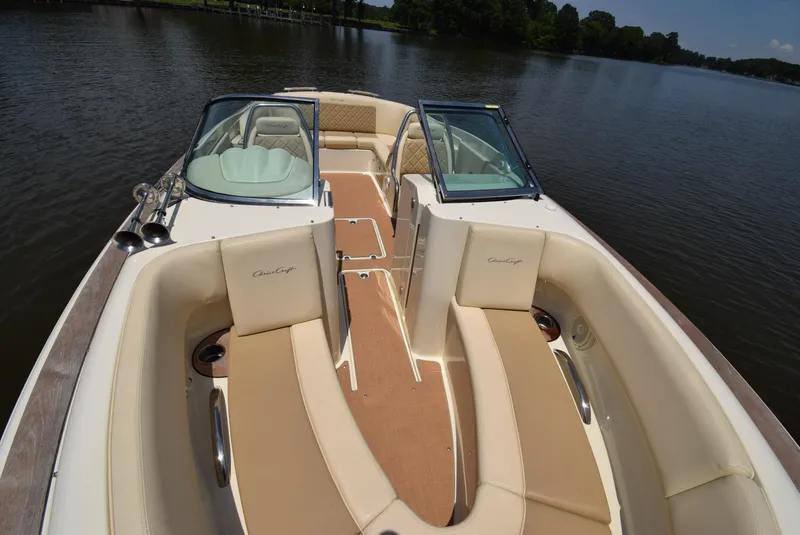 Slide: The Image of 2017 Chris-Craft Launch 25 boat interior with beige seating on a calm lake. - 14