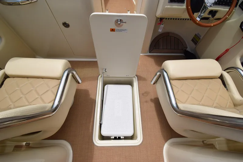 Slide: The Image of 2017 Chris-Craft Launch 25 interior with storage compartment and beige seating. - 16