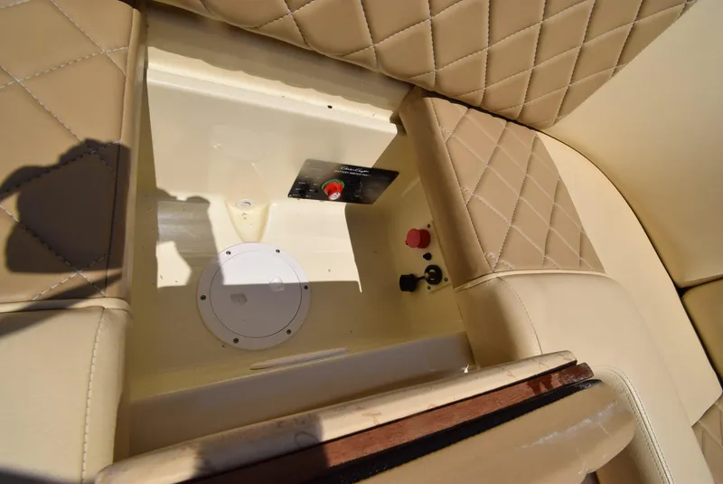 Slide: The Image of 2017 Chris-Craft Launch 25 interior storage compartment with beige quilted seats. - 17