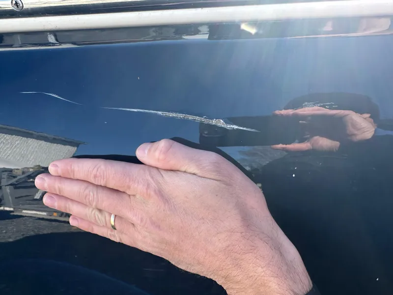 Slide: The Image of Scratch on 2017 Chris-Craft Launch 25 boat hull with hand for scale. - 24