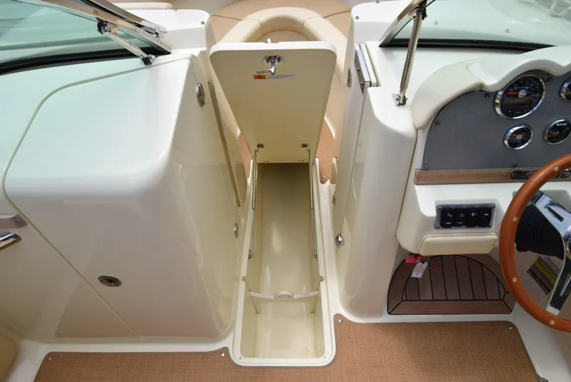 Slide: The Image of 2017 Chris-Craft Launch 25 boat interior with open storage compartment and dashboard. - 26