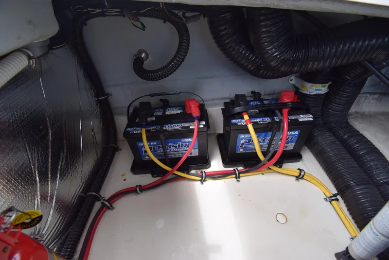 Slide: The Image of 2017 Chris-Craft Launch 25 boat battery compartment with wiring and dual batteries. - 28