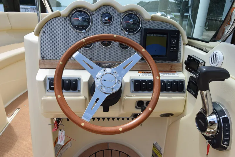Slide: The Image of 2017 Chris-Craft Launch 25 dashboard with wooden steering wheel and modern controls. - 3