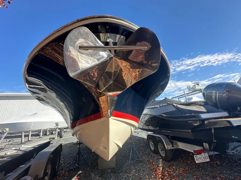 Slide: The Image of 2017 Chris-Craft Launch 25 boat with anchor, parked on trailer under clear blue sky. - 32