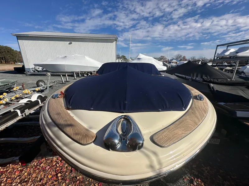 Slide: The Image of 2017 Chris-Craft Launch 25 boat with cover, parked outdoors under blue sky. - 33