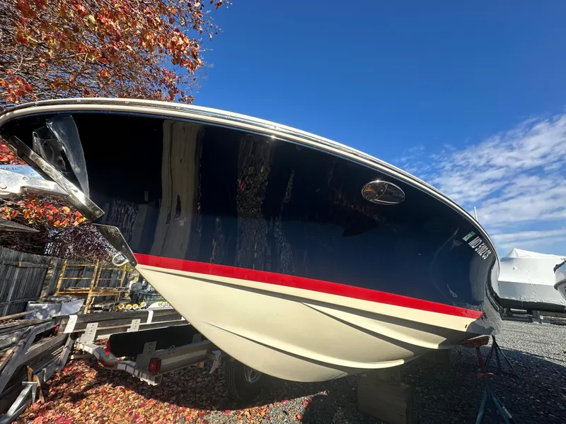 Slide: The Image of 2017 Chris-Craft Launch 25 boat on trailer, surrounded by autumn leaves and clear blue sky. - 34