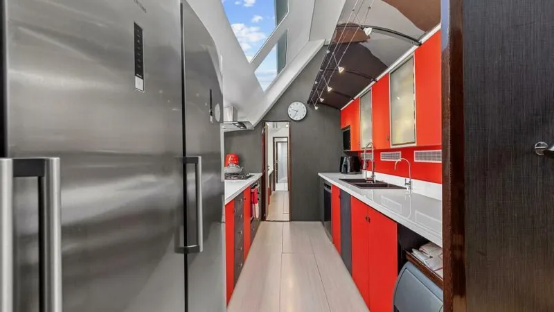 Slide: The Image of Modern yacht kitchen with red cabinets, stainless steel appliances, and sleek design, 2023 Mystique Yachts. - 31