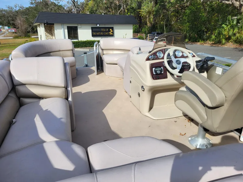 Slide: The Image of 2013 Xcursion X23RFC pontoon boat with spacious seating and modern dashboard. - 6