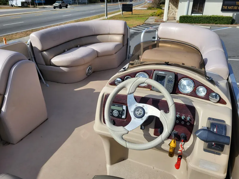 Slide: The Image of Interior of 2013 Xcursion X23RFC pontoon boat with beige seating and steering console. - 9