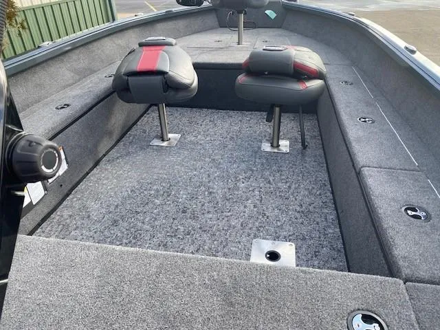 Slide: The Image of 2025 Ranger VS1665T boat interior with gray carpet and two swivel seats. - 2