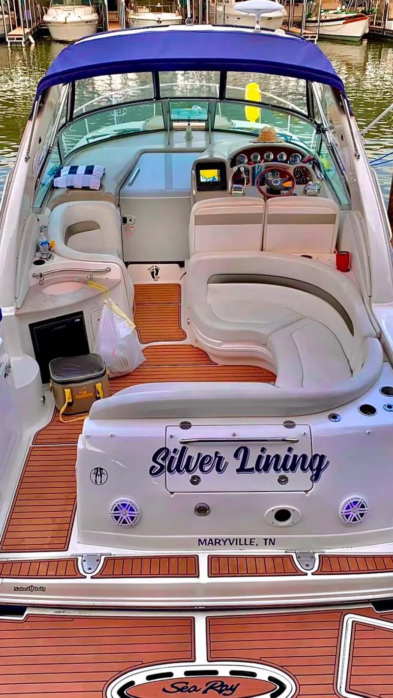 Slide: The Image of 2006 Sea Ray 320 Sundancer boat named "Silver Lining" docked, featuring spacious seating and wood accents. - 3
