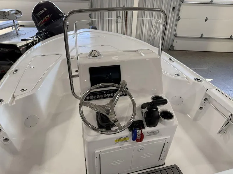 Slide: The Image of 2025 Tidewater 1910 BM boat console with steering wheel and controls in a garage setting. - 15