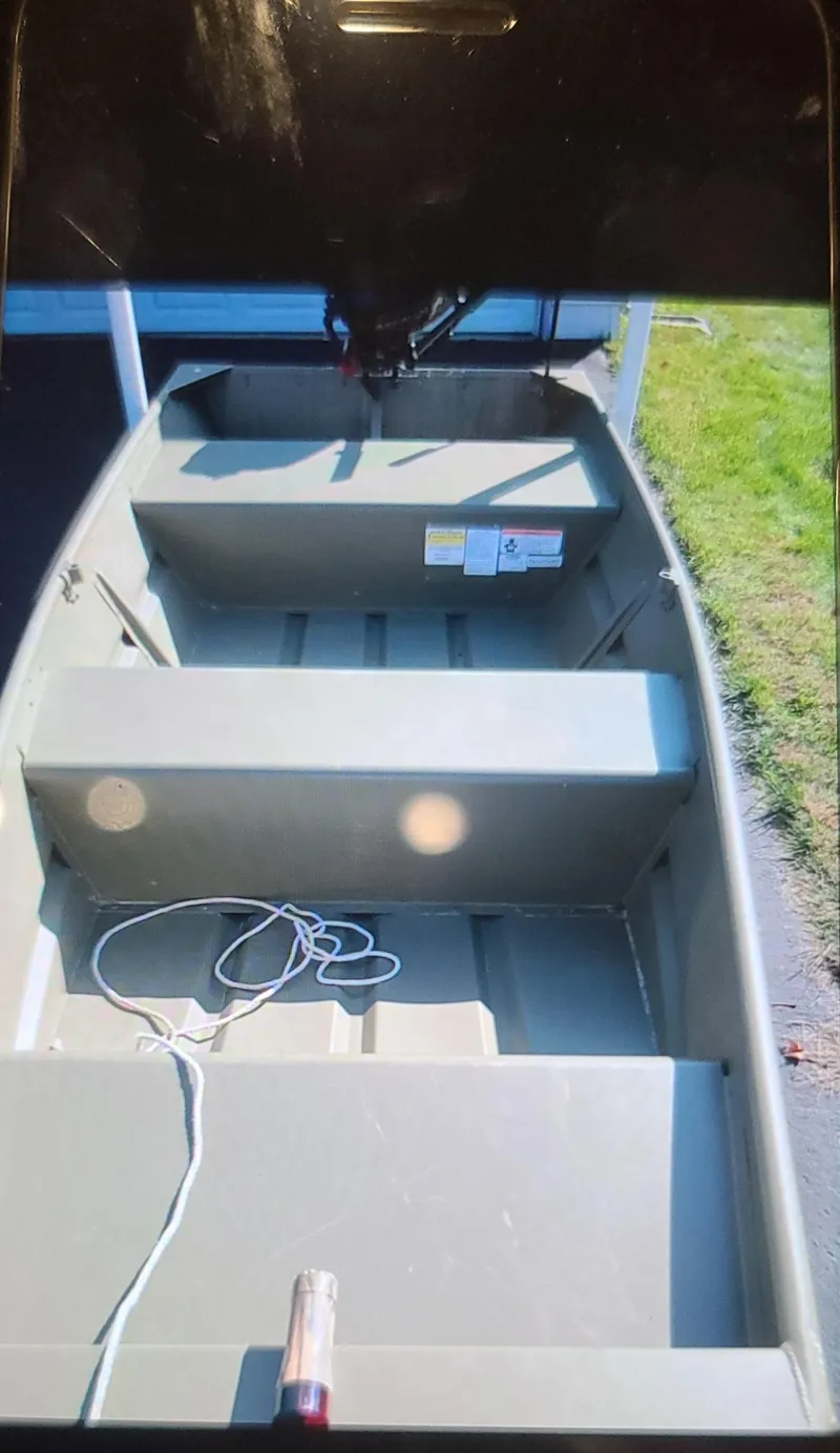 Slide: The Image of 2017 Tracker Topper 1036 Riveted Jon boat, interior view with rope, parked on grass. - 5