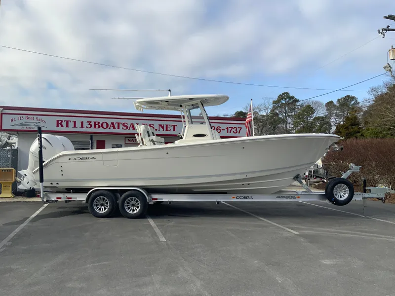 The Image of 2025 Cobia 285 Open Center Console boat on trailer at dealership. - 1