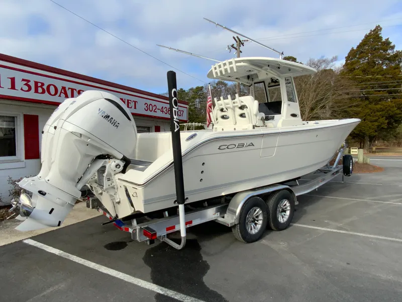 Slide: The Image of 2025 Cobia 285 Open Center Console boat on trailer, parked outside dealership. - 11