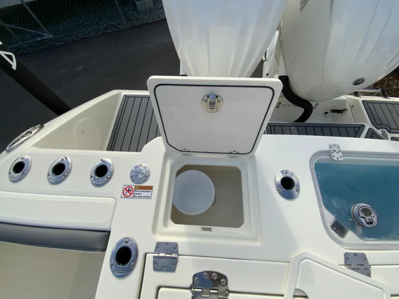 Slide: The Image of 2025 Cobia 285 Open Center Console boat deck with storage compartments and rod holders. - 18