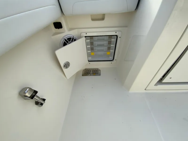 Slide: The Image of 2025 Cobia 285 Open Center Console interior detail with storage compartment and speaker. - 21