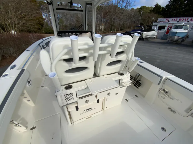 Slide: The Image of 2025 Cobia 285 Open Center Console boat interior with rod holders and storage compartments. - 24