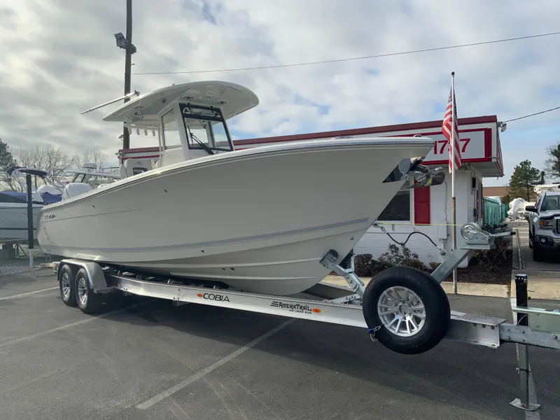 Slide: The Image of 2025 Cobia 285 Open Center Console boat on trailer, parked outdoors. - 3