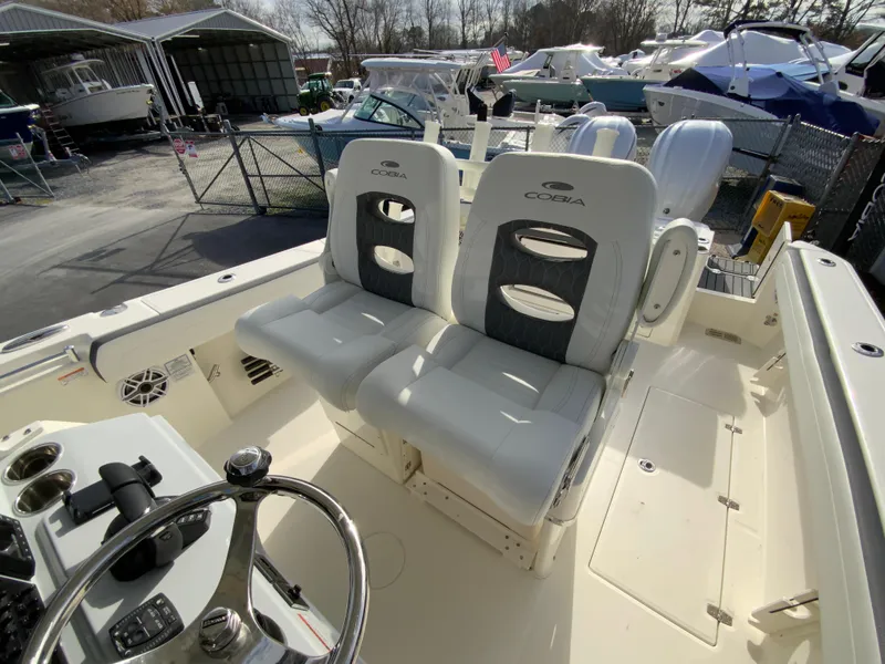 Slide: The Image of 2025 Cobia 285 Open Center Console boat interior with dual seating and steering wheel. - 42
