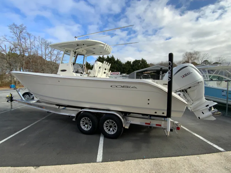 Slide: The Image of 2025 Cobia 285 Open Center Console boat on trailer, parked outdoors. - 8