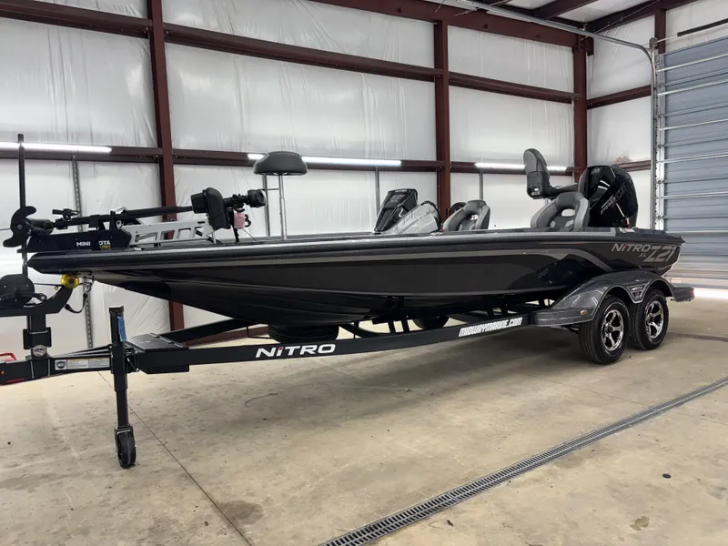 Slide: The Image of 2025 Nitro Z21 XL Pro boat in a garage, sleek design, dual seats, and trailer. - 13