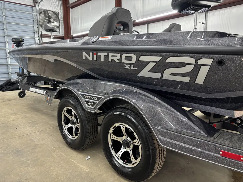 Slide: The Image of 2025 Nitro Z21 XL Pro boat in a garage, showcasing sleek design and dual-axle trailer. - 15